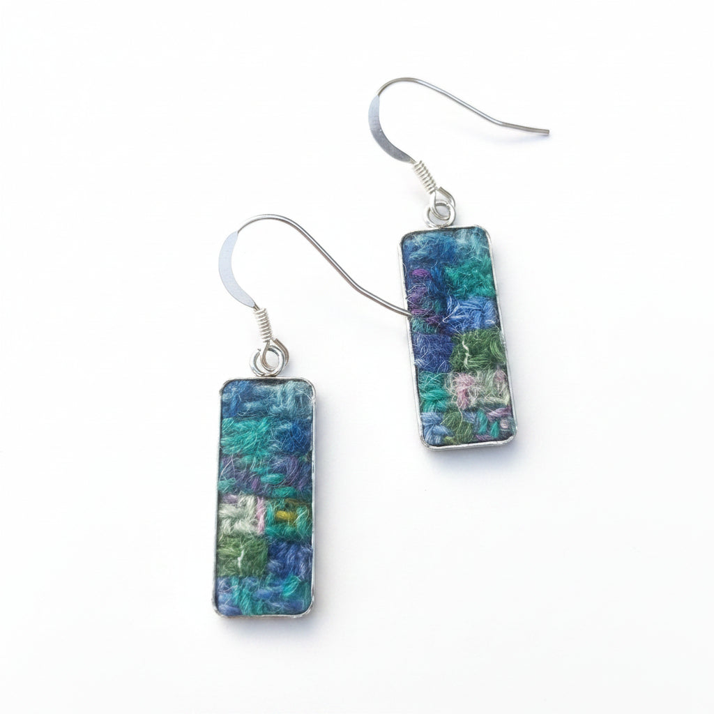 Rectangular earrings with blue and green pattern on a white surface
