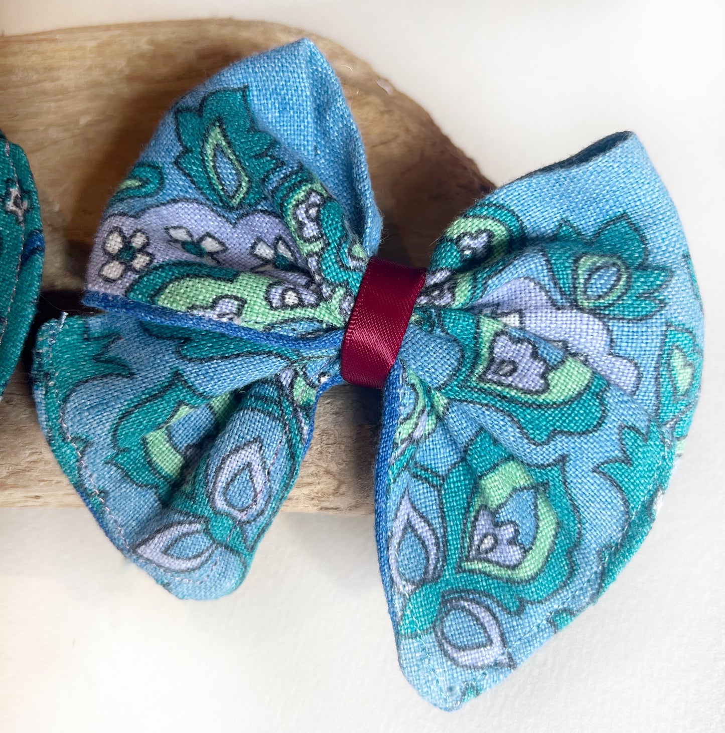 Vintage fabric blue paisley hair bows being added with maroon ribbon