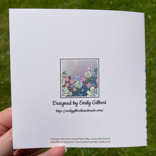 White back of greetings card with thumbnail of front image with website details underneath 