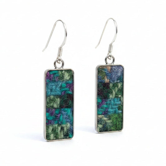 Rectangular earrings with a checkered pattern on a wooden surface